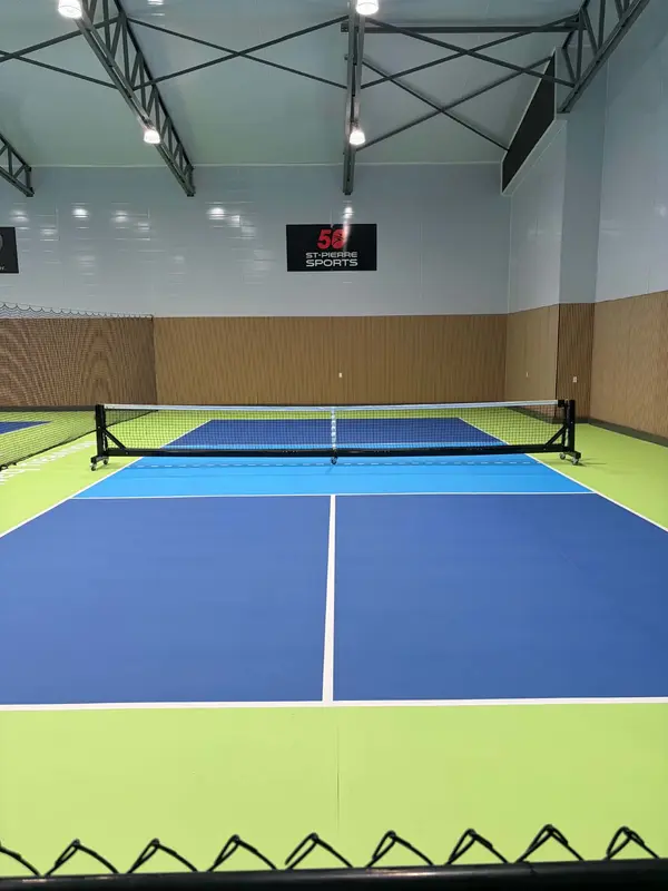 Terrain de pickleball intérieur, enseigne St-Pierre Sports au mur du fond